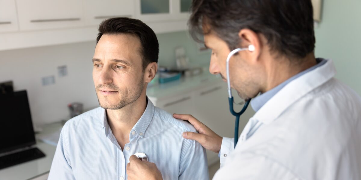 doctor examining man with stethoscope on chest