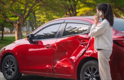 young asian woman on phone after car accident
